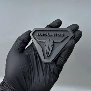 フェンダーバッドランズロングホーンカーエンブレムバッジロゴ フォードブロンコブラックオンMブラックトラックオフロード4x4 SUVトラック車に安全な粘着剤で簡単に取り付けられます。