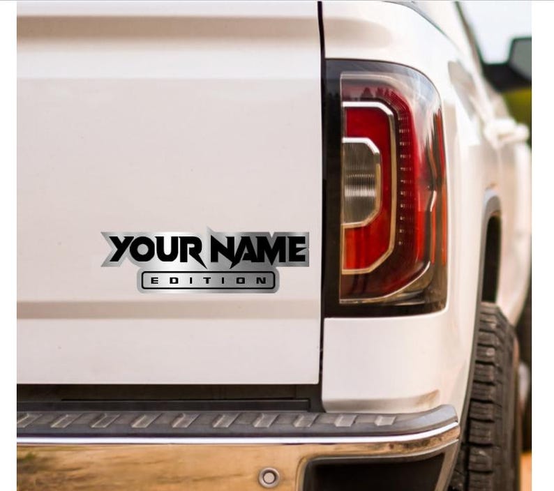 Puede incluir: Una camioneta blanca con una calcoman&iacute;a plateada y negra que dice "YOUR NAME EDITION".