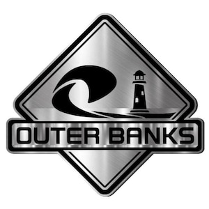 May include: A silver and black diamond-shaped emblem with the words "OUTER BANKS" in a rectangular box at the bottom. The emblem features a black wave and a lighthouse silhouette.