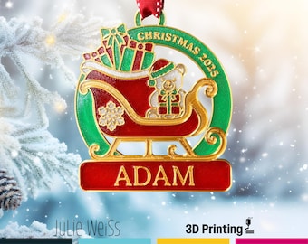 Puede incluir: Adorno navideño personalizado con un trineo rojo y dorado, un oso de peluche y regalos. El adorno tiene el nombre "ADAM" y el año "2025". Colgando de una cinta roja y blanca. El texto "CHRISTMAS ORNAMENTS" es visible.