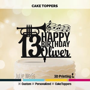 May include: A black cake topper with a trumpet, musical notes, and the number 13. The text reads "HAPPY BIRTHDAY Oliver". The bottom of the topper has the text "Julie Weiss" and "3D Printing". The words "Custom", "Personalized", and "Cake Toppers" are also present.