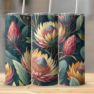 Puede incluir: Tres vasos aislados con un diseño floral. El diseño presenta flores grandes y estilizadas en tonos de amarillo, rosa y naranja sobre un fondo verde azulado oscuro. Cada vaso tiene una pajita blanca.