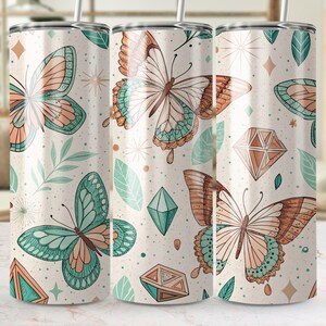 May include: Three stainless steel tumblers with a white background and a pattern of butterflies and geometric shapes in shades of green, brown, and orange.