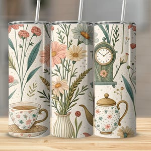 May include: Three stainless steel tumblers with floral and tea-themed designs. Each tumbler features a different illustration, including flowers, a clock, a teapot, and a teacup. The tumblers have a straw and are decorated with pastel colors.