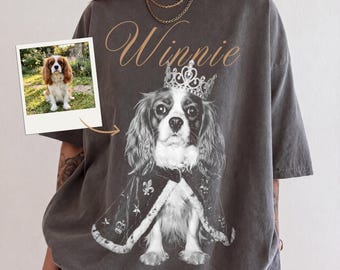 Könnte beinhalten: Ein anthrazitfarbenes T-Shirt mit einer Grafik eines Cavalier King Charles Spaniels, der eine Krone und einen königlichen Umhang trägt. Der Name Winnie ist in Schreibschrift über dem Hund gedruckt. Ein kleines quadratisches Foto ist links.
