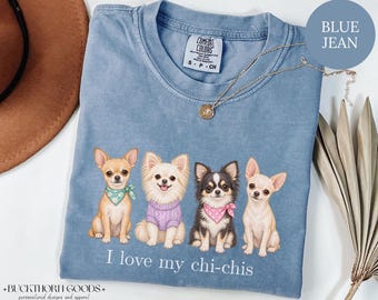 Könnte beinhalten: Ein blaues T-Shirt mit einer Grafik von vier Chihuahua-Hunden, die in einer Reihe sitzen. Die Hunde tragen ein grünes Halstuch, einen lila Pullover, ein rosa gepunktetes Halstuch und kein Accessoire. Der Text I love my chi-chis steht darunter.