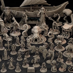Könnte beinhalten: Eine Sammlung unbemalter grauer Miniaturfiguren, die verschiedene Fantasiewesen, Krieger und mythische Gestalten darstellen, zusammen mit zwei detaillierten Langschiffen mit Segeln, die auf einer dunklen Oberfläche angeordnet sind.