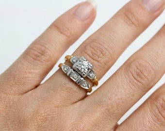 May include: A two-piece ring set featuring a central round diamond set in white metal on a yellow gold band, paired with a matching guard ring containing smaller diamonds in a white metal setting on a yellow gold band.