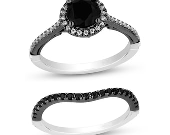 May include: A black diamond engagement ring set with a halo of smaller diamonds. The ring is set in black rhodium plated silver and has a matching wedding band.