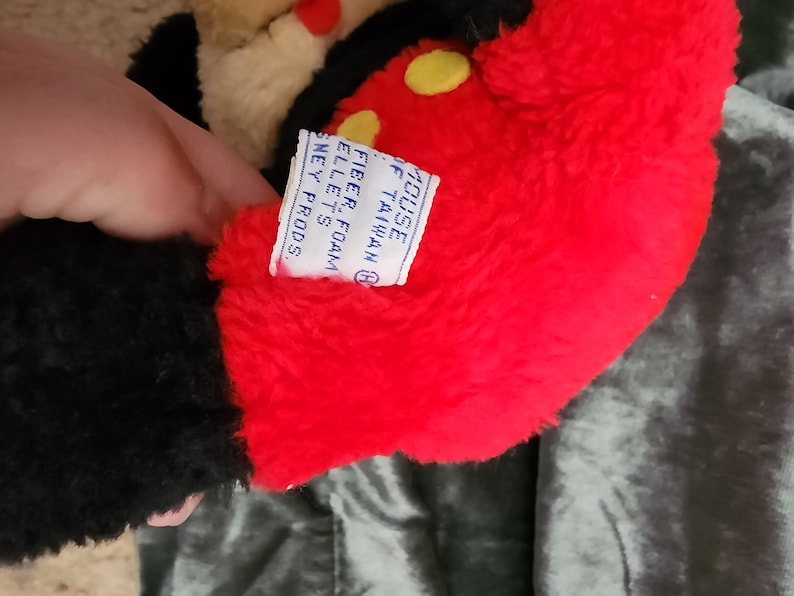 May include: Black and red plush Mickey Mouse toy with a yellow button on the chest. The tag reads "House of Mouse, Taiwan, Fiber Foam Pellet's, Disney Prods."