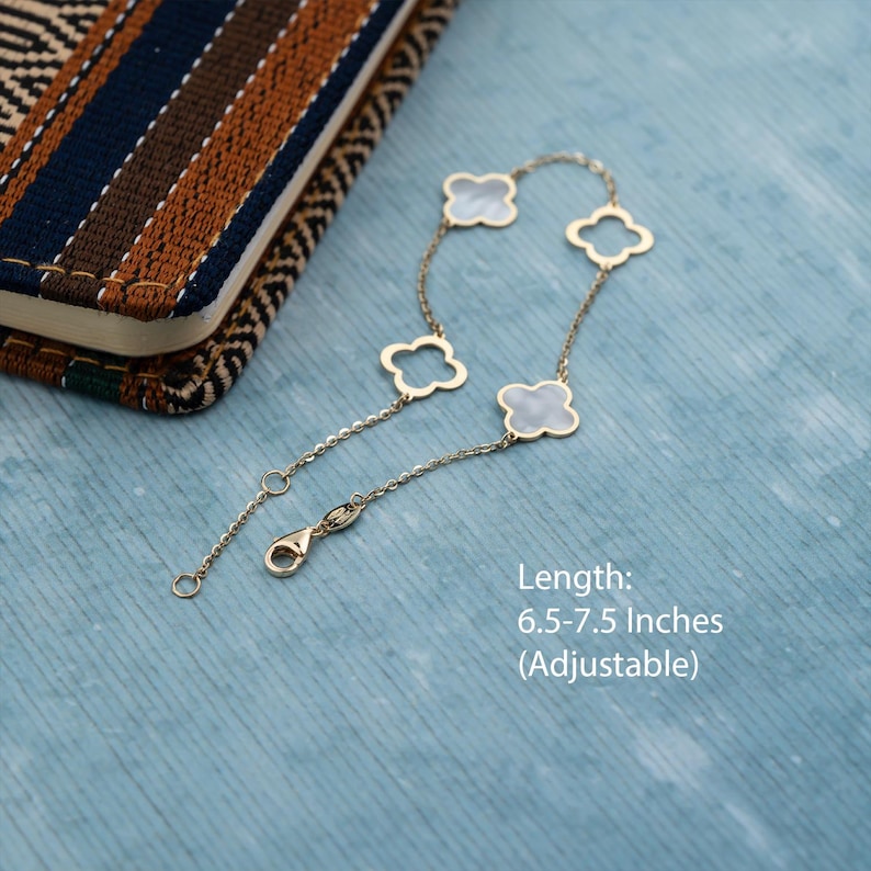 Puede incluir: Un brazalete de cadena dorada con cuatro dijes de tr&eacute;bol blanco. El brazalete es ajustable y mide 6.5-7.5 pulgadas de largo.