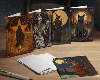 May include: A collection of greeting cards with gothic and Halloween-themed illustrations. The cards feature images of a robed figure, a skeleton, a witch, and a black cat. The cards are displayed on a wooden surface with a pen and blank envelopes.