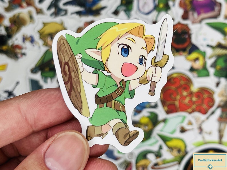May include: A cartoon sticker of Link from The Legend of Zelda video game series. Link is wearing his signature green tunic and holding a sword and shield. The sticker is white with a black outline.