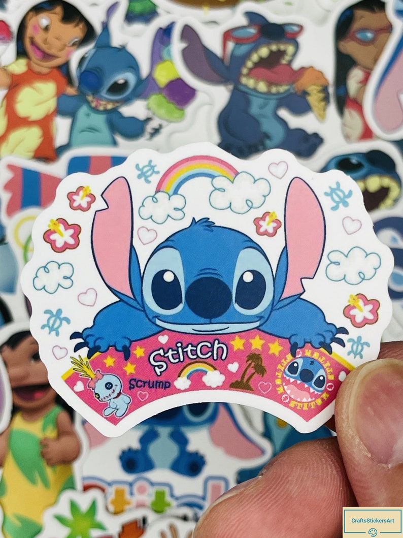 Puede incluir: Una pegatina con Stitch de Lilo & Stitch. La pegatina es blanca con un arco&iacute;ris rosa, azul y amarillo, nubes, corazones y flores. Stitch es azul con ojos grandes y una nariz rosa. El texto "Stitch" est&aacute; escrito en rosa con un contorno blanco. El texto "Scrump" est&aacute; escrito en rosa debajo de Stitch.