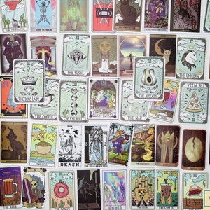 May include: A set of 36 tarot card stickers featuring various illustrations, including a cat, a unicorn, a pizza, a donut, a cactus, and a skull. The stickers are printed on white paper with a light green background.