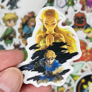 May include: A sticker featuring a watercolour-style illustration of Link and Zelda from the Legend of Zelda video game series. Link is in the foreground, wearing blue and green armour, and Zelda is in the background, with long blonde hair and a white dress.