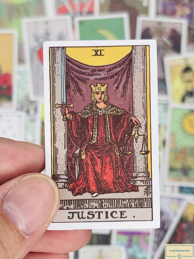 May include: A tarot card with a white background and a colorful illustration of a figure wearing a crown and red robe holding a sword and scales. The card is labeled "Justice" and "XI".