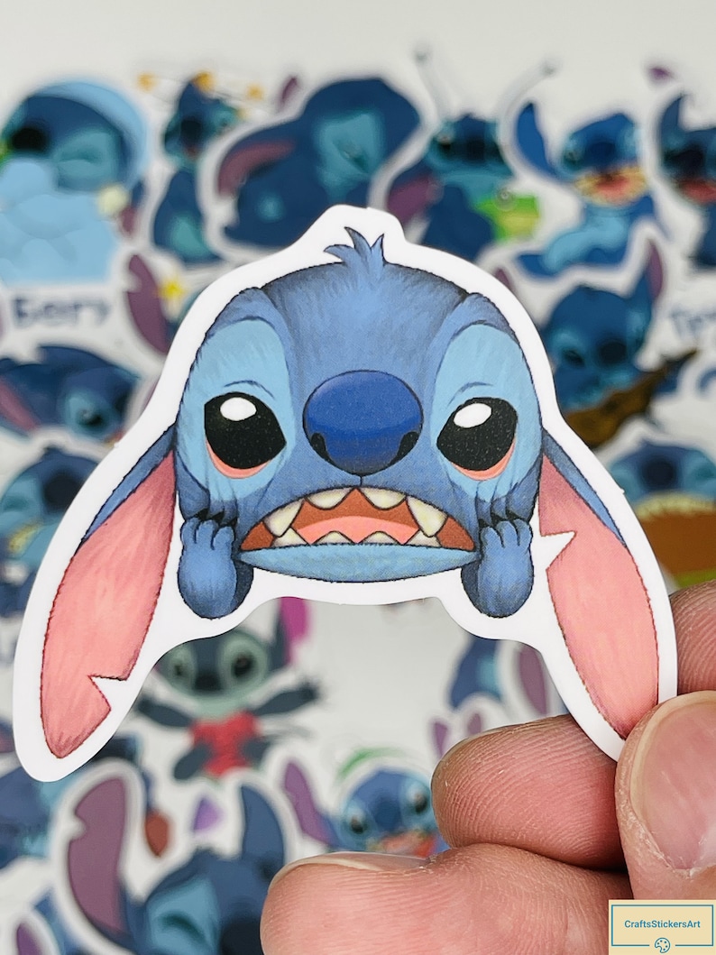 Puede incluir: Una pegatina de personaje de dibujos animados azul y rosa con una expresi&oacute;n de preocupaci&oacute;n. El personaje tiene ojos grandes, una boca ancha y dos orejas rosas. La pegatina forma parte de un conjunto de pegatinas que presentan al mismo personaje en diferentes poses.