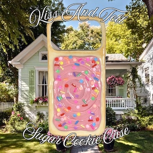 May include: A rectangular phone case designed to resemble a frosted pastry with pink icing and colorful sprinkles. The text Kiss And Tell is printed at the top, and the text Sugar Cookie Case is printed at the bottom of the phone case.