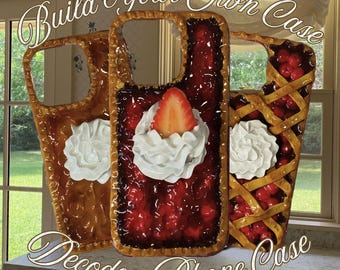 May include: Three decorative phone cases designed to resemble pie slices. One is brown with white frosting, another has red filling with a strawberry and whipped cream, and the third has a lattice crust with red filling. Text reads "Build Your Own Case" and "Decoden Phone Case."