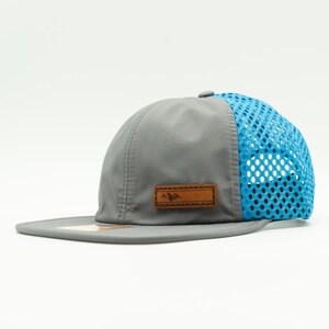 Side view of gray and cyan Richardson 935 performance hat with brown leather Active Mountain patch, water resistant mesh back outdoors hat for hiking, camping and lake days