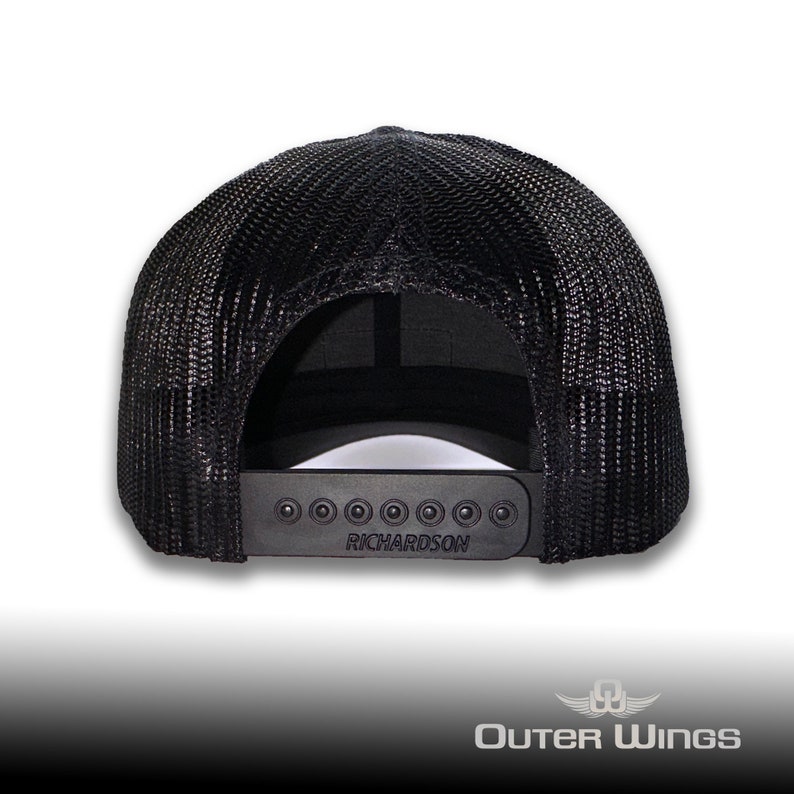 May include: Black trucker hat with a mesh back and a curved brim. The adjustable snap closure features the brand name "RICHARDSON". The hat is designed with a classic, casual style.