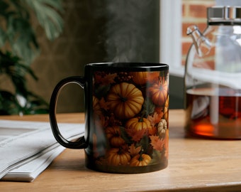 May include: Black ceramic mug with a fall-themed design featuring orange, brown, and yellow pumpkins and leaves. Steam is rising from the mug.