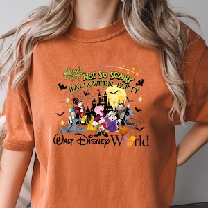 May include: Orange t-shirt with a graphic of Mickey Mouse and friends in a Halloween scene. The text reads "Mickey's Not So Scary Halloween Party Walt Disney World".