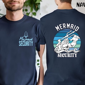Puede incluir: Camiseta azul marino con texto "Mermaid Security" y un tridente en la parte delantera. La parte trasera presenta un gráfico de un tritón musculoso con un tridente, texto "Mermaid Security" y un fondo a rayas.