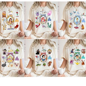 May include: Set of six white t-shirts with different Disney princess designs. Each shirt features a different princess with a variety of other characters and symbols from their respective movies. The designs include Cinderella, Snow White, Belle, Ariel, Jasmine, and Rapunzel.