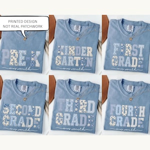 Pode incluir: Seis t-shirts azuis com um design estampado estilo patchwork com níveis escolares como Pre-K, Kindergarten, First, Second, Third e Fourth Grade. Cada t-shirt inclui o texto Mrs. Smith e um balão com PRINTED DESIGN NOT REAL PATCHWORK.