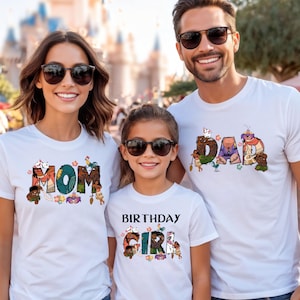 May include: A family of three wearing white t-shirts with a Moana theme. The shirts feature the words "Mom", "Dad", and "Birthday Girl" with Moana characters and elements from the film.