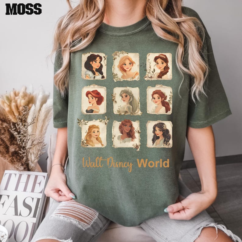 May include: A green t-shirt with a print of nine Disney princesses in frames. The text "Walt Disney World" is printed below the frames.