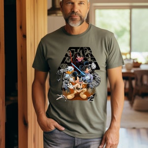 May include: A green t-shirt with a graphic print of Mickey Mouse, Donald Duck, and Minnie Mouse dressed as Star Wars characters. The text "Star Wars" is printed above the characters.