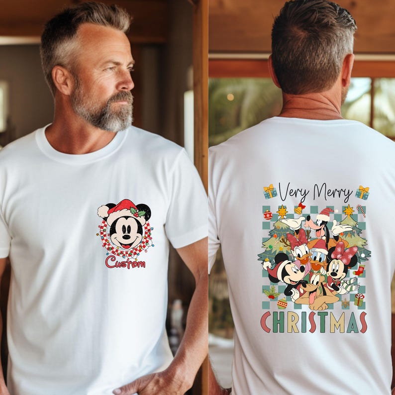 Pode incluir: Camiseta branca com Mickey Mouse usando um chap&eacute;u de Papai Noel e a palavra "Custom" abaixo. A parte de tr&aacute;s da camiseta exibe um design "Muito Feliz Natal" com personagens da Disney, &aacute;rvores de Natal e presentes.