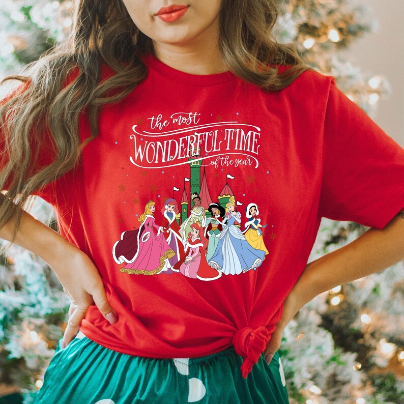 May include: Red t-shirt with a white graphic of Disney princesses in front of a castle with the text "the most WONDERFUL TIME of the year".