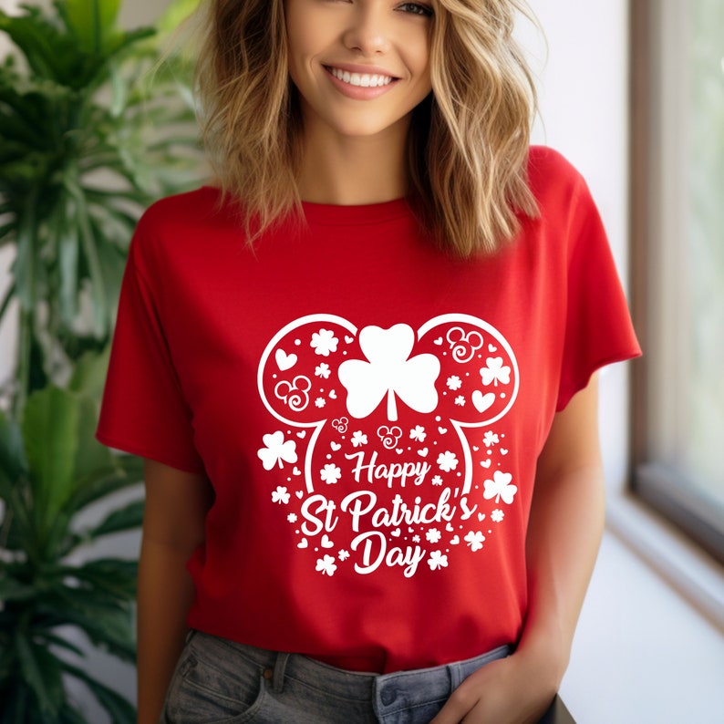 May include: Red t-shirt with a white design of a Mickey Mouse head with shamrocks and hearts. The text "Happy St. Patrick's Day" is written below the Mickey Mouse head.