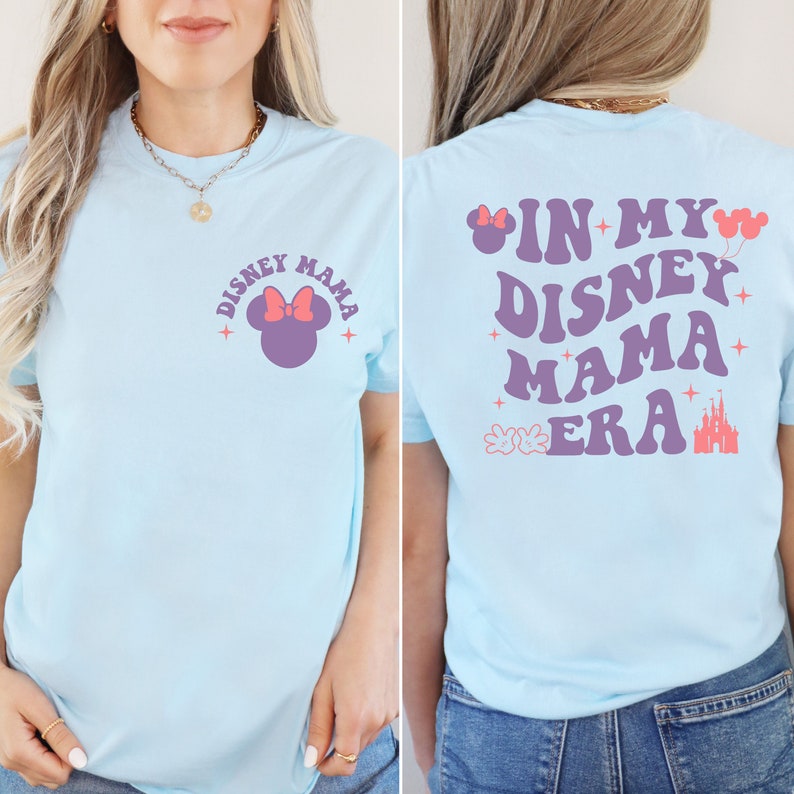 May include: Pale blue t-shirt featuring the text "DISNEY MAMA" and a Minnie Mouse design on the front. The back of the shirt displays "IN MY DISNEY MAMA ERA" with Disney-themed graphics.