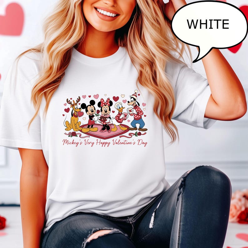 Puede incluir: Camiseta blanca con un gr&aacute;fico colorido de los personajes de Disney Mickey, Minnie, Donald y Goofy celebrando el D&iacute;a de San Valent&iacute;n. La frase "Mickey's Very Happy Valentine's Day" est&aacute; impresa debajo del gr&aacute;fico. La palabra "WHITE" est&aacute; en una burbuja.