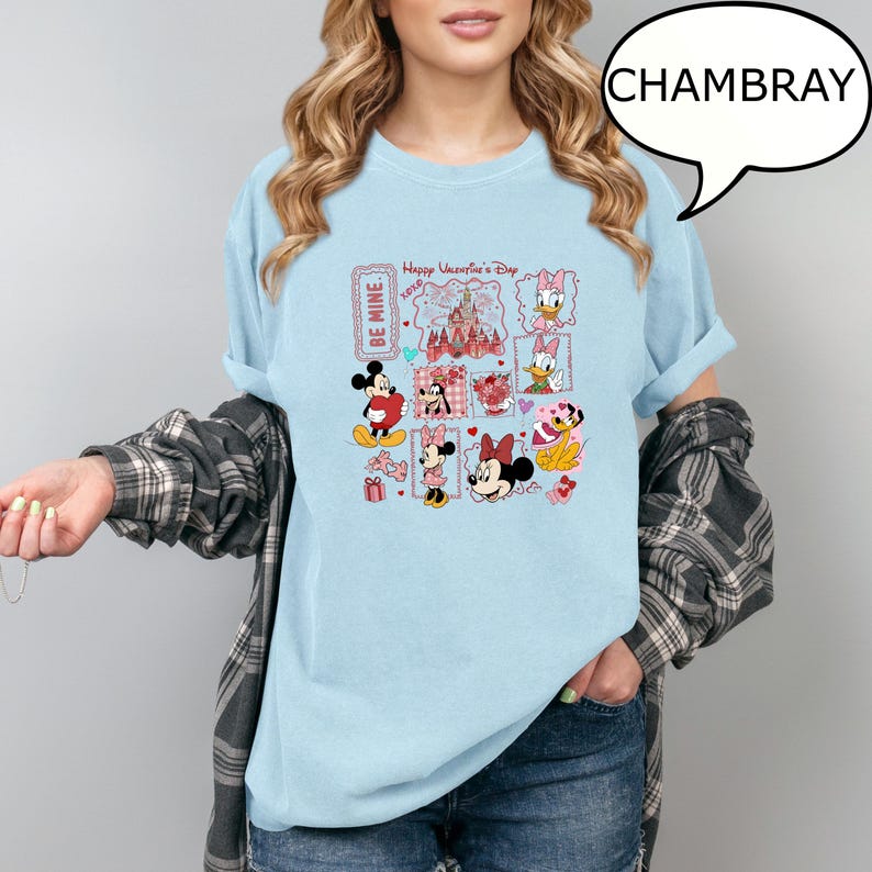May include: Light blue t-shirt with a Valentine's Day graphic featuring Mickey and Minnie Mouse, Daisy Duck, and other Disney characters. The graphic includes the text "Happy Valentine's Day" and "Be Mine."