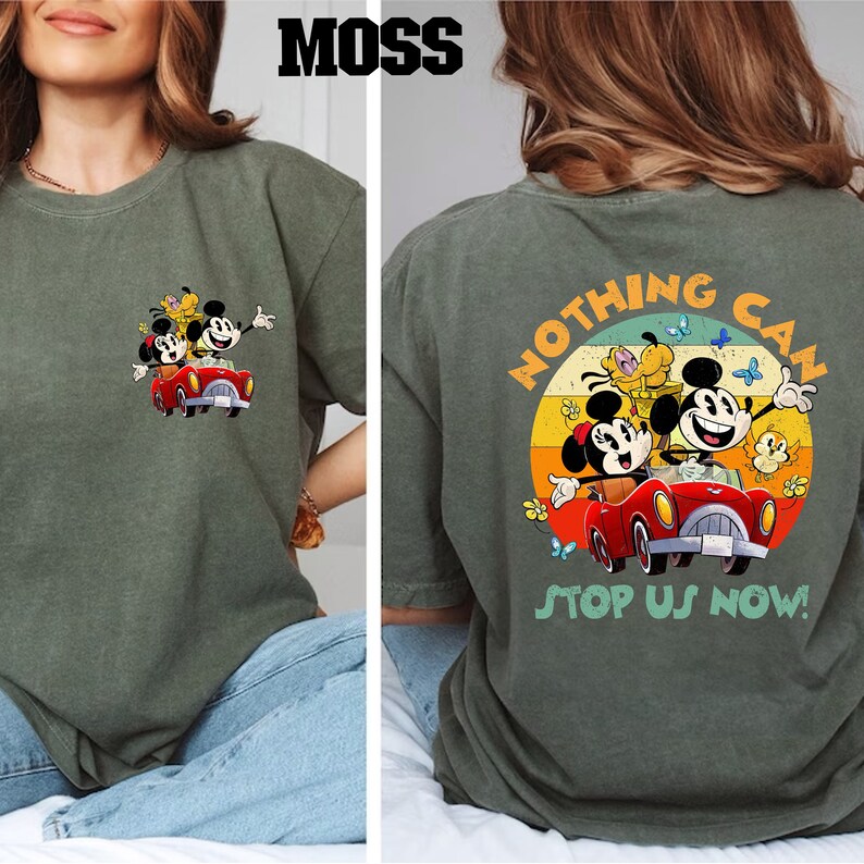 以下が含まれることがあります： 赤い車に乗ったミッキーマウス、ミニーマウス、プルートのヴィンテージスタイルのグラフィックが描かれた緑色のTシャツ。シャツの後ろには「Nothing Can Stop Us Now!」の文字が書かれています。