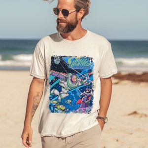 May include: White t-shirt with a graphic print of Buzz Lightyear from the Toy Story franchise. The graphic features Buzz Lightyear in his space ranger suit, flying through space with a laser blast. The text "Buzz Lightyear Laser Blast" is printed above the graphic.