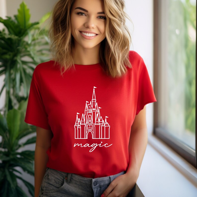 May include: A red t-shirt with a white outline of Cinderella's castle and the word "magic" underneath.