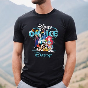 May include: Black t-shirt with a blue and white graphic of Disney characters on ice. The graphic includes Mickey Mouse, Minnie Mouse, Donald Duck, Goofy, Elsa, Anna, and Ariel. The text "Disney on Ice" is above the characters and the text "Daddy" is below the characters.