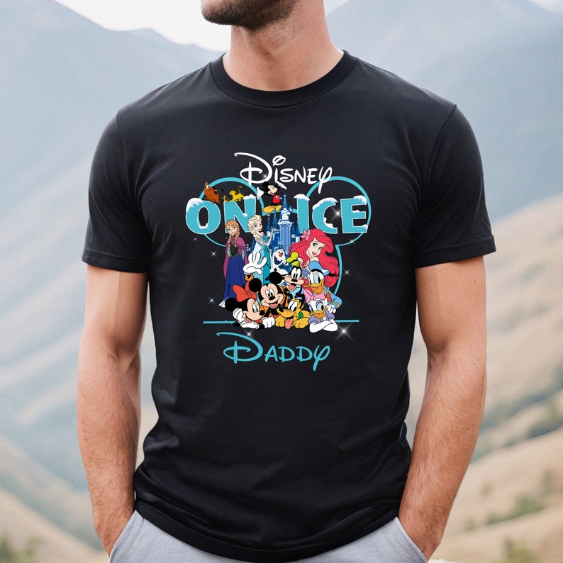 May include: Black t-shirt with a blue and white graphic of Disney characters on ice. The graphic includes Mickey Mouse, Minnie Mouse, Donald Duck, Goofy, Elsa, Anna, and Ariel. The text "Disney on Ice" is above the characters and the text "Daddy" is below the characters.