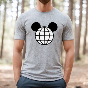 K&ouml;nnte beinhalten: Ein graues T-Shirt mit einer schwarz-wei&szlig;en Grafik eines Globus mit Mickey-Maus-Ohren.