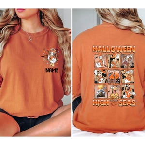 K&ouml;nnte beinhalten: Orangefarbenes Langarmshirt mit Halloween-Motiv. Auf der Vorderseite befindet sich eine Cartoonfigur mit dem Wort "NAME" darunter. Auf der R&uuml;ckseite sind "HALLOWEEN" und Cartoonfiguren in Quadraten zu sehen.
