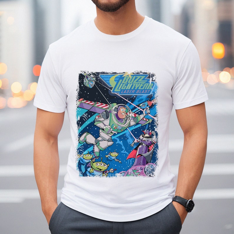 May include: White t-shirt with a distressed graphic print of Buzz Lightyear from Toy Story. The graphic features Buzz in his space ranger suit flying through space with a laser blast. The text "Buzz Lightyear Laser Blast" is printed above him.