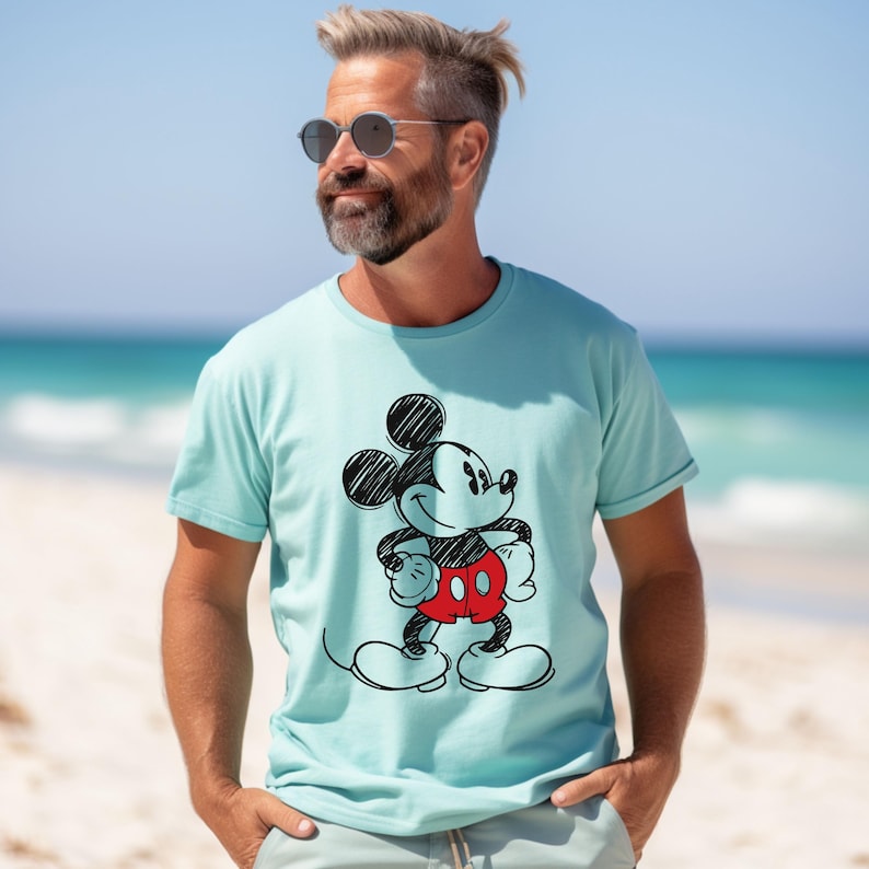 May include: A light blue t-shirt with a black and white sketch of Mickey Mouse wearing red shorts.