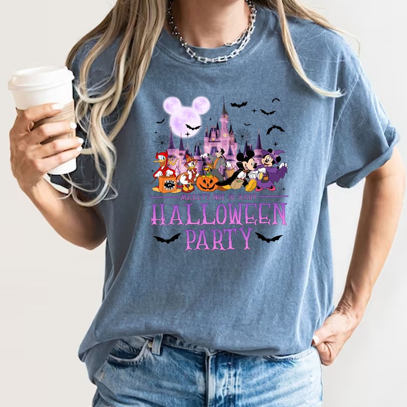 May include: A blue t-shirt with a purple print of Mickey Mouse and friends in front of the Disney castle. The text "Mickey's Not So Scary Halloween Party" is printed below the image.